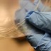 Graduate student Chong Hou holds a bag of drawn fibers. The fibers are as thin as 100 micrometers in diameter, and the material coating further enhances the strength of the fibers. Photo: Jose-Luis Olivares/MIT